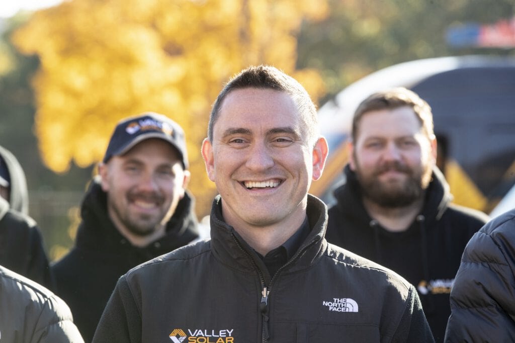 Valley Solar team smiling outdoor in fall with solar energy awareness.