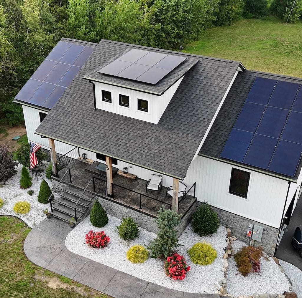 Solar panels installed on the roof of a modern farmhouse, showcasing renewable energy solutions for homes.