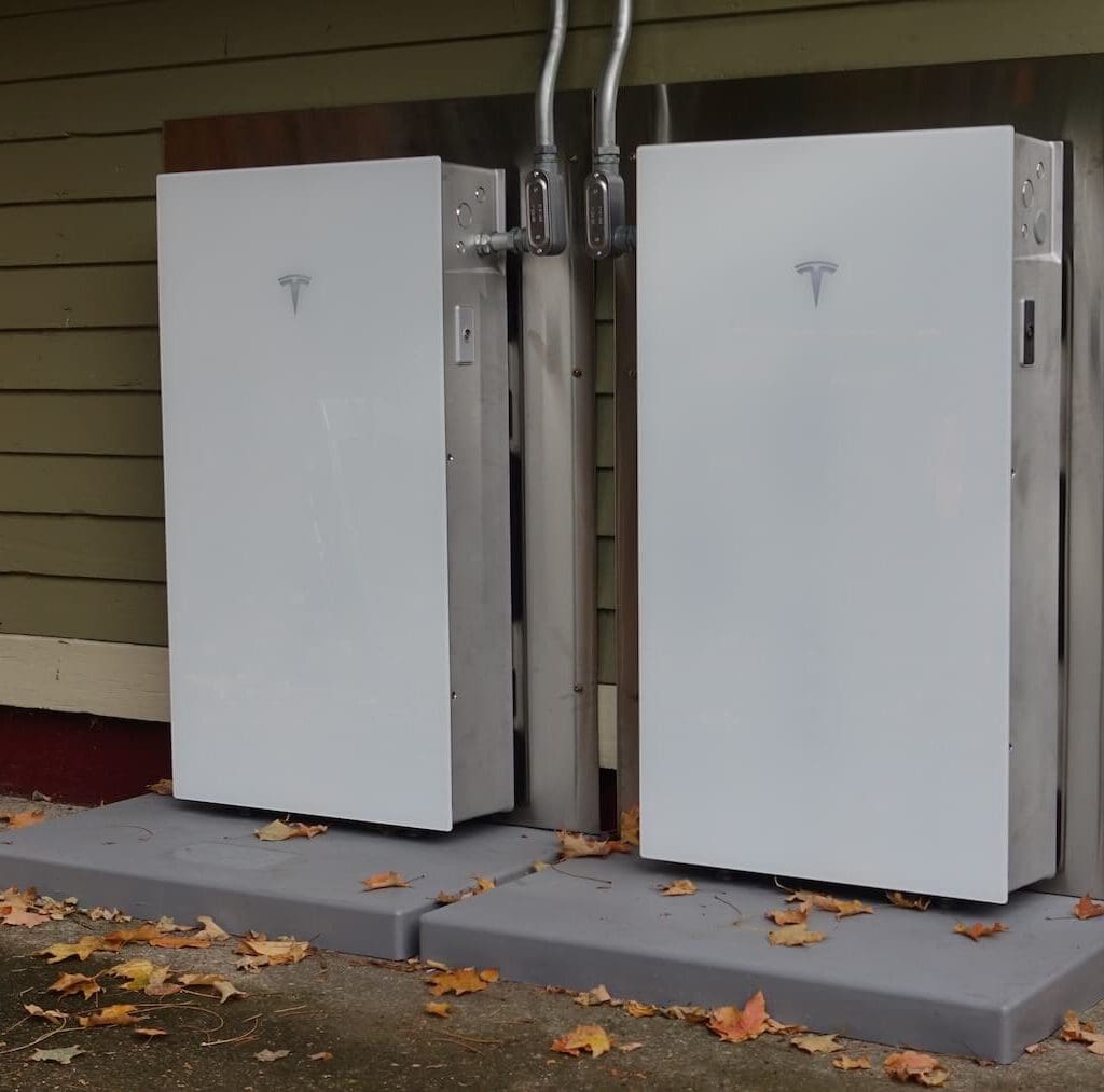 Electric vehicle charging station with Tesla chargers installed outdoors.