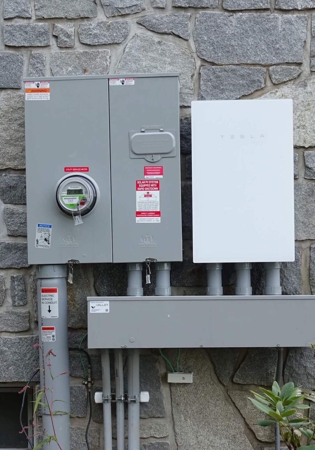 High-efficiency solar power system and Tesla energy inverter installed outdoors.